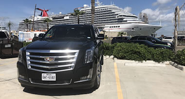 black luxury vehicle with luxury cruise ship in the background